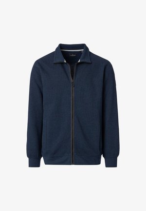 Marineblå lynlåsjakke med ribbet krave, struktureret stof og elastiske manchetter. Har en lynlås foran og diskret mærkning på brystet.