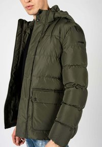 Groene gewatteerde jas met een capuchon, voorzien van een ritssluiting en drukknoopsluiting, zijzakken en een gladde, glanzende textuur. Geox-logo op de mouw.