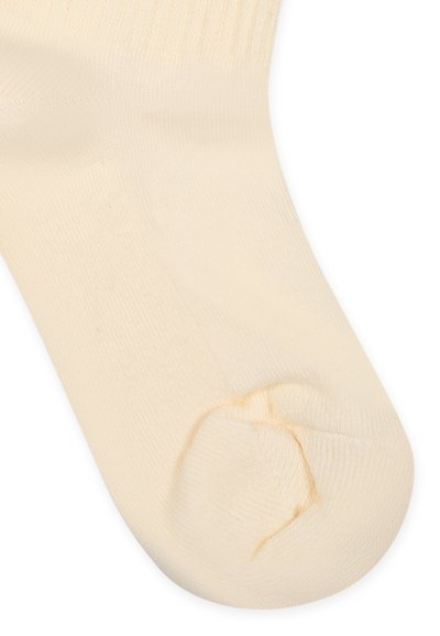 Chaussette en coton couleur crème avec texture côtelée, orteil sans couture et talon renforcé. Conception légère avec finition lisse.