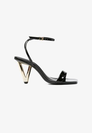 Zwarte lakleren sandaal met hoge hak, vierkante neus, enkelbandje met gesp en een gouden driehoekige blokhak.