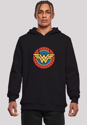 Fekete kapucnis póló, amelyen egy nagy Wonder Woman logo található piros, sárga és kék színekben, kerek formában, csillagokkal körülvéve.
