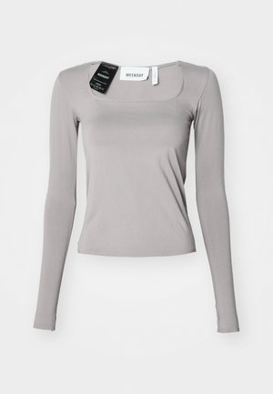 Camisa de manga longa em cinza claro, com decote quadrado, corte justo e tecido suave. Inclui etiquetas presas ao decote.