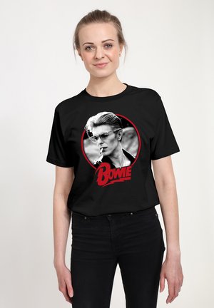 Black t-shirt featuring a graphic of a man with slicked-back hair and glasses, smoking. "Bowie" in bold red letters below the image.