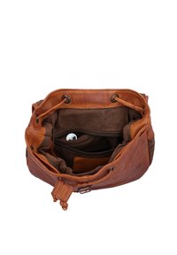 Borsa a mano in pelle marrone aperta che mostra una tasca interna con zip contenente auricolari wireless bianchi e un portafoglio in pelle marrone.