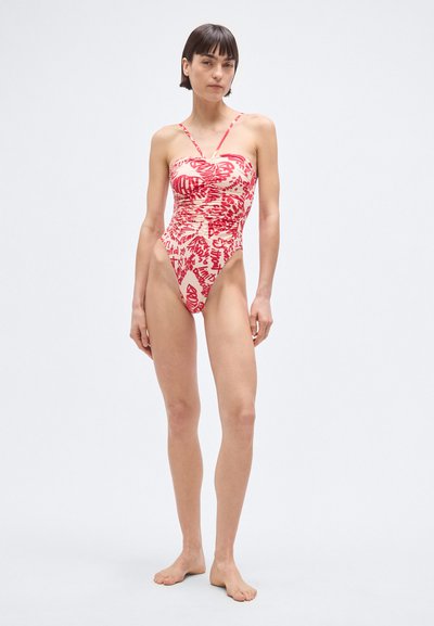 Bañador de una pieza en rojo y crema con tirantes finos ajustables, cuerpo fruncido, aberturas de pierna altas y patrones abstractos audaces.