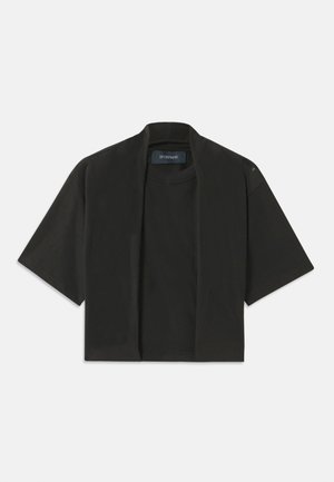 Camiseta negra recortada de mangas cortas, hecha de material suave. Presenta un escote redondo y un corte relajado. Detalle de costura sutil en el hombro.