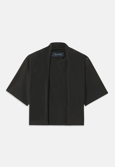 Black cropped t-shirt with short sleeves, made of soft material. Features a round neckline and a relaxed fit. Subtle stitching detail at shoulder.