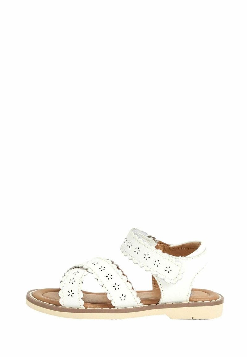 Sandalo bianco con una fascia testurizzata, caratterizzata da motivi floreali ritagliati, punta tonda e suola beige. Chiusura a strap regolabile.