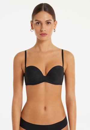 Reggiseno nero imbottito con sottili spalline regolabili, tessuto liscio, coppe sagomate e un design senza cuciture. Stile minimalista senza decorazioni.