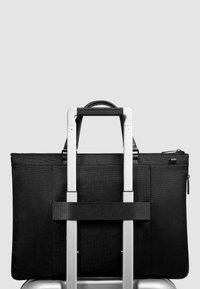 Schwarze Stofftasche in rechteckiger Form, mit glatter Oberfläche, Reißverschluss und einem Gurt zum Befestigen an einem Trolleygriff.