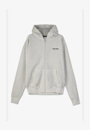 Felpa grigia chiara con zip, realizzata in tessuto morbido, caratterizzata da una tasca frontale a marsupio e un logo nero sul petto. Include un cappuccio e polsini a costine.