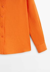 Orangenes Langarmshirt aus leichtem Stoff. Verfügt über eine vordere Knopfleiste mit passenden Knöpfen und einen geraden Saum. Einfaches Kragen- und Manschettendesign.