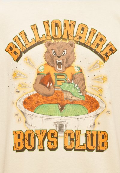 Μπεζ μπλουζάκι με γραφικό ενός αρκούδου με πορτοκαλί φανέλα που κρατάει ένα ποδόσφαιρο, με την επιγραφή «Billionaire Boys Club» πάνω και εικόνες γηπ έδου από κάτω.