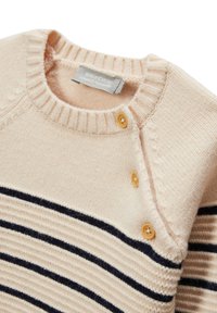 Pull en tricot beige avec des rayures horizontales marine. Doté d'un col rond côtelé et de trois boutons en bois sur l'épaule. Texture douce.