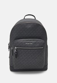 Sac à dos en tissu noir avec motif de logo, compartiments à double zip, poche avant et une poignée supérieure. Présente un design épuré et des accents en matériel argenté.