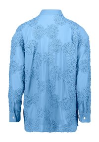 Chemise bleu clair ornée d'appliqués floraux texturés dans tout le vêtement. Manches longues avec poignets à boutons, col et finition en tissu lisse.