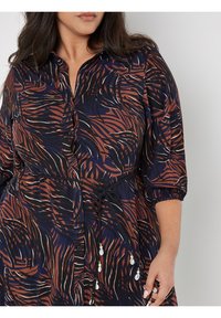 Maxikleid in dunklem Marineblau und Braun mit einem abstrakten Blattmuster, Knopfleiste vorne, 3/4-Ärmeln und einem verstellbaren Taillengurt mit Perlenakzenten.