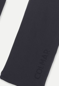 Sötétkék leggings sima anyagból, diszkrét domború logóval, és letisztult formatervezéssel, látható záródás vagy mintázat nélkül.
