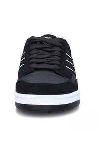 Sneaker nere con tomaia in suede e puntale perforato. Presentano strisce e lacci bianchi, con una suola intermedia bianca e una suola esterna in gomma nera.