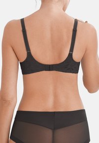 Black bra featuring a textured design, adjustable straps, and a hook-and-eye closure at the back. Complemented by black mesh briefs.