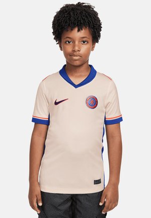 Maillot de football beige avec col et accents de manches bleus. Présente le logo Nike et un emblème d'équipe rond. Texture lisse, manches courtes, design en v.