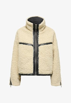 Cream-colored shearling jacket with a black zip front, contrasting black horizontal stripes, high collar, and zippered cuffs.