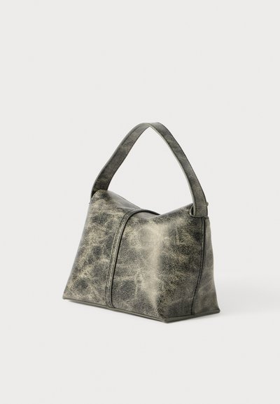 Borsa in pelle grigia con forma triangolare, una sola maniglia e una finitura morbida e textured. Presenta cuciture sottili e nessun accento in metallo.