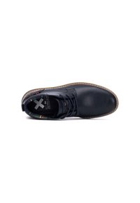 Zapato de piel negra con punta redonda, suela de goma marrón y forro de diseño colorido. Presenta un diseño tradicional de cordones.