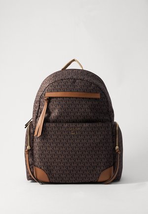 Brun Michael Kors rygsæk med overalt MK logo mønster, frontlomme, sidelommer med lynlås og tan læderdetaljer mod hvid baggrund.