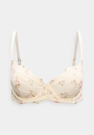 Soutien-gorge en dentelle crème avec motifs floraux en rose et vert. Armatures, avec bords festonnés et bretelles ajustables pour un meilleur ajustement.