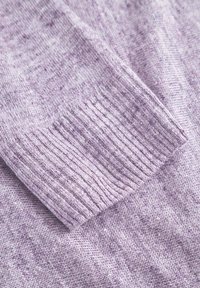 Hellblau gestrickter Pulloverstoff mit einem gerippten Bund, glatter Textur und subtilen Farbschattierungen sowie Mustervariationen.