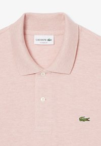 Ljusrosa polotröja med klassisk passform, som har en ribbad krage, treknapplåda och en grön broderad krokodil-logga.