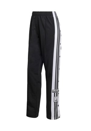 Černé sportovní kalhoty s bílými vertikálními pruhy, cvočky po stranách a logem Adidas na spodní části nohy.