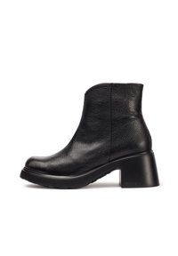 Botas de tobillo negras hechas de cuero texturizado, con punta redondeada, tacón bloque de altura media y suela de goma. Acentos de costura sencilla.