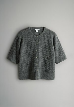 Harmaa neulottu neuletakki lyhyillä hihoilla, joissa on kaapelikuvio ja pyöreä kaula-aukko. Edessä on napit ja ribatut hihansuut.