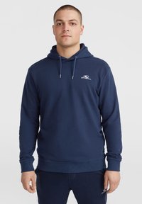 Sweatshirt à capuche bleu marine en tissu mélange de coton, avec des manches longues, des poignets côtelés, et un logo brodé sur la poitrine.