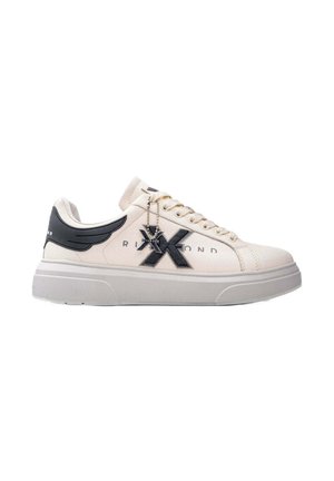 Sneaker crema e nera con dettaglio decorativo a forma di ali, caratterizzato da un logo prominente e una suola chunky, esposto su uno sfondo bianco.