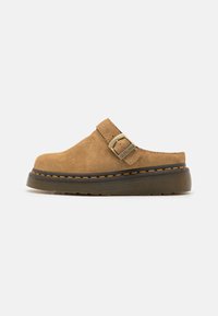 Suede clogs in light tan with a buckle strap. Chunky black sole accented with orange stitching. Simple, rounded design with closed back.