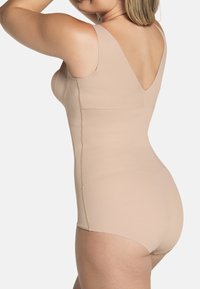 Nackter Bodysuit aus glattem, dehnbarem Material. Mit V-förmigem Rückendesign, breiten Trägern und nahtloser Verarbeitung für maximalen Komfort.