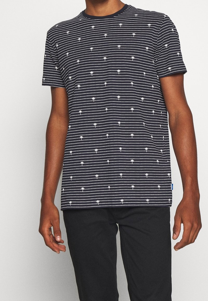 Granatowa koszulka z krótkim rękawem z poziomymi białymi paskami i powtarzającym się wzorem palm. Wykonana z miękkiego materiału o luźnym kroju.