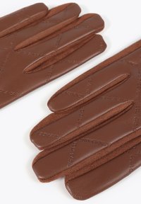 Hnědé kožené rukavice s měkkým nubukovým akcentem, s třemi zakřivenými otvory na prsty a reliéfními detaily značky na povrchu.