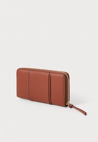 Barna bőr pénztárca texturált felülettel, cipzáras záródással, három kártyatartóval és csuklópánttal a hordozhatóság érdekében.