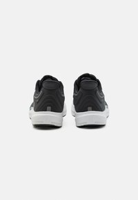 Scarpe sportive nere con una parte superiore testurizzata, accenti curvi in grigio scuro e una suola intermedia bianca. Progettate con un collo imbottito per il comfort.