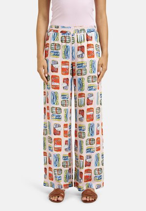 Wide-leg pants with colorful canned fish print, elastic waistband, worn with light pink top and brown open-toe sandals on a white background.