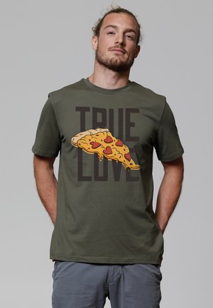 Olijfgroene T-shirt met een grafische afbeelding van een stuk pizza met een hartpatroon en de tekst "ECHTE LIEFDE" in vetgedrukte zwarte letters.