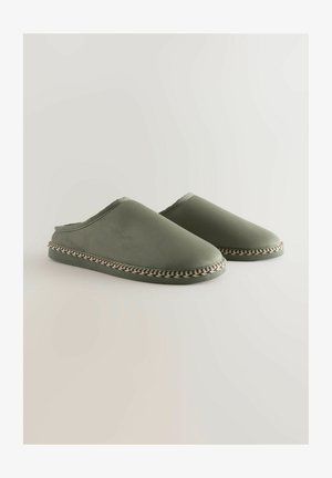 Zelené nazouvací pantofle s hladkým povrchem, s tkaným lemem v černé a béžové barvě kolem podrážky a otevřenou zadní částí.