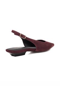 Burgundy suede slingback shoes with a pointed toe and a small block heel. Features an adjustable strap and a smooth black insole.