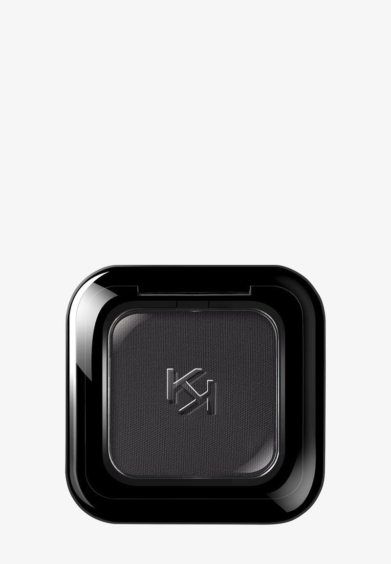 Fard à paupières noir compact avec logo "KJ" en relief, dans un boîtier carré noir brillant, sur fond gris clair.