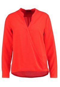 Blouse rouge à manches longues avec un design à nouer devant et un petit col montant avec un décolleté en V.