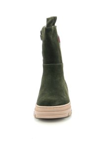 Botín de ante verde con punta redondeada, suela de goma beige y tirador en la parte posterior. Presenta detalles de costura mínimos.